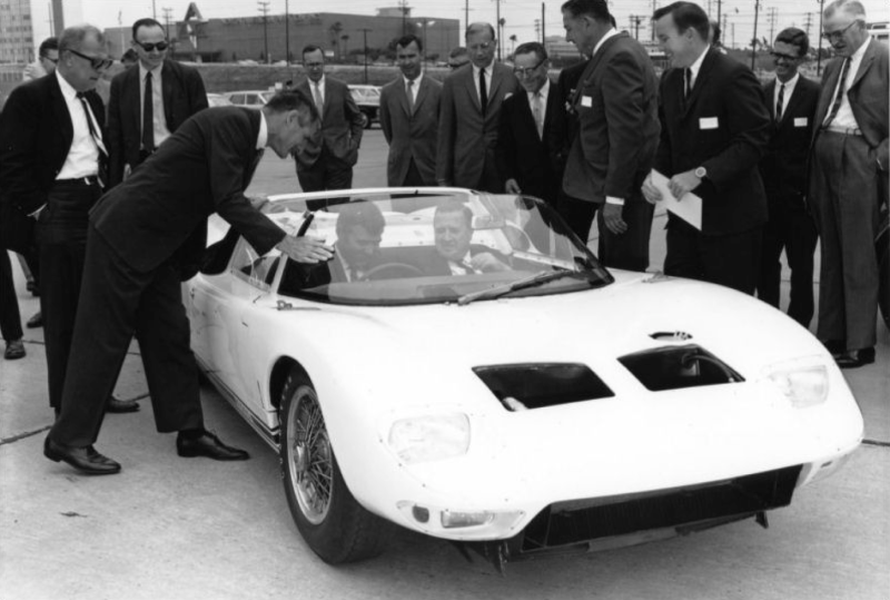 Carroll Shelby (seated, left) and Henry Ford II (seated, right) in a 1965 GT40 108 Roadster.