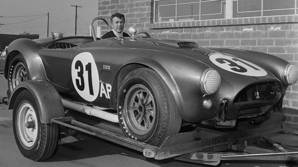 Carroll Shelby sitting in a Shelby Cobra.