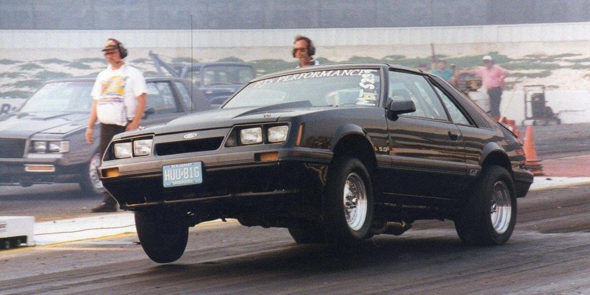 Black foxbody mustang launching at drag strip