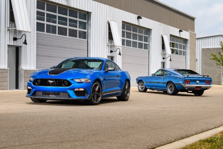 Blue Ford Mustangs in front of warehouse