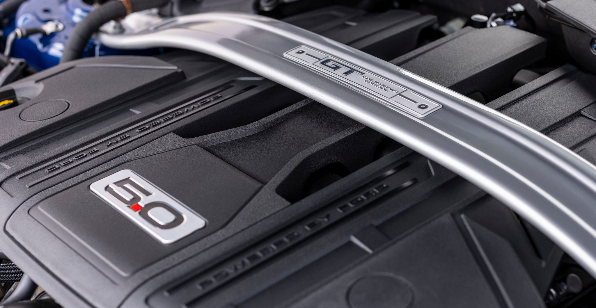 Closeup of a strut bar in the engine bay of a Ford Mustang