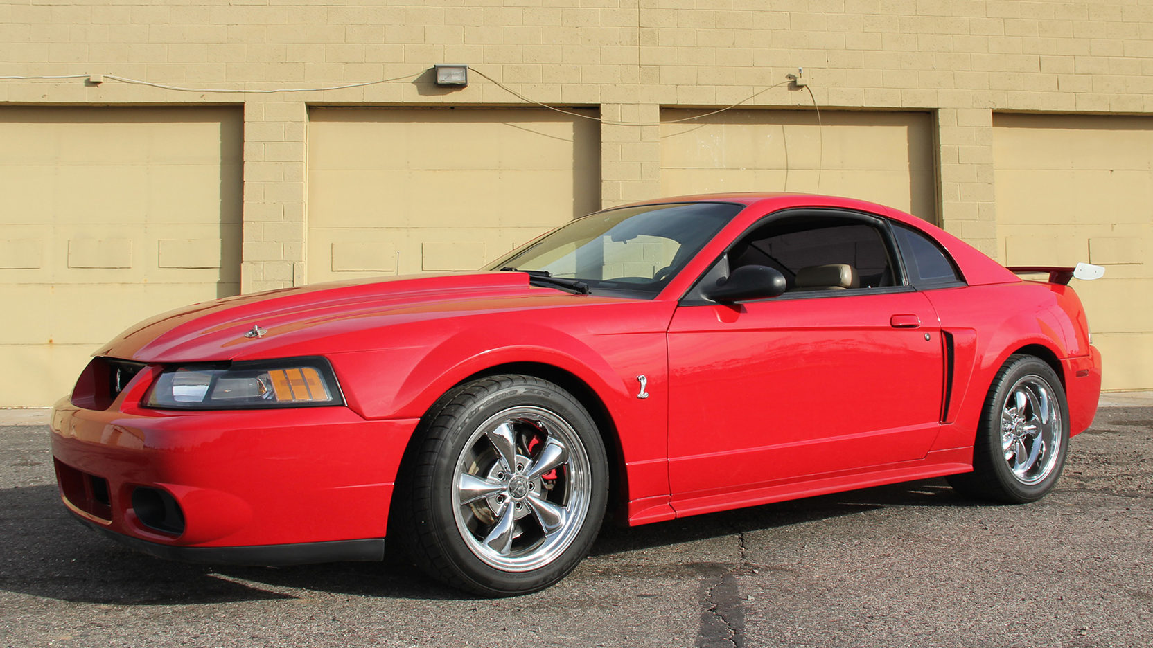 Red 1999 Mustang SVT Cobra in front of garage