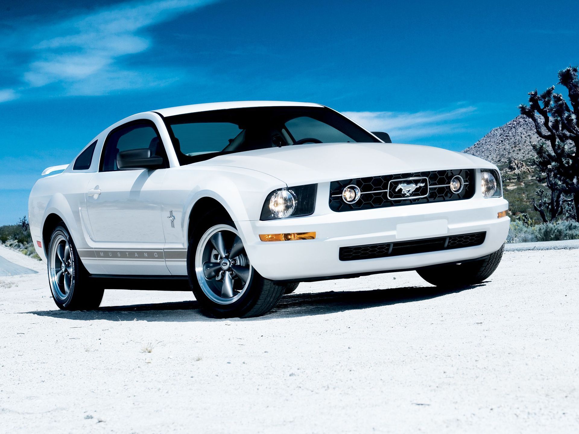 White 2006 Mustang V6 on desert road