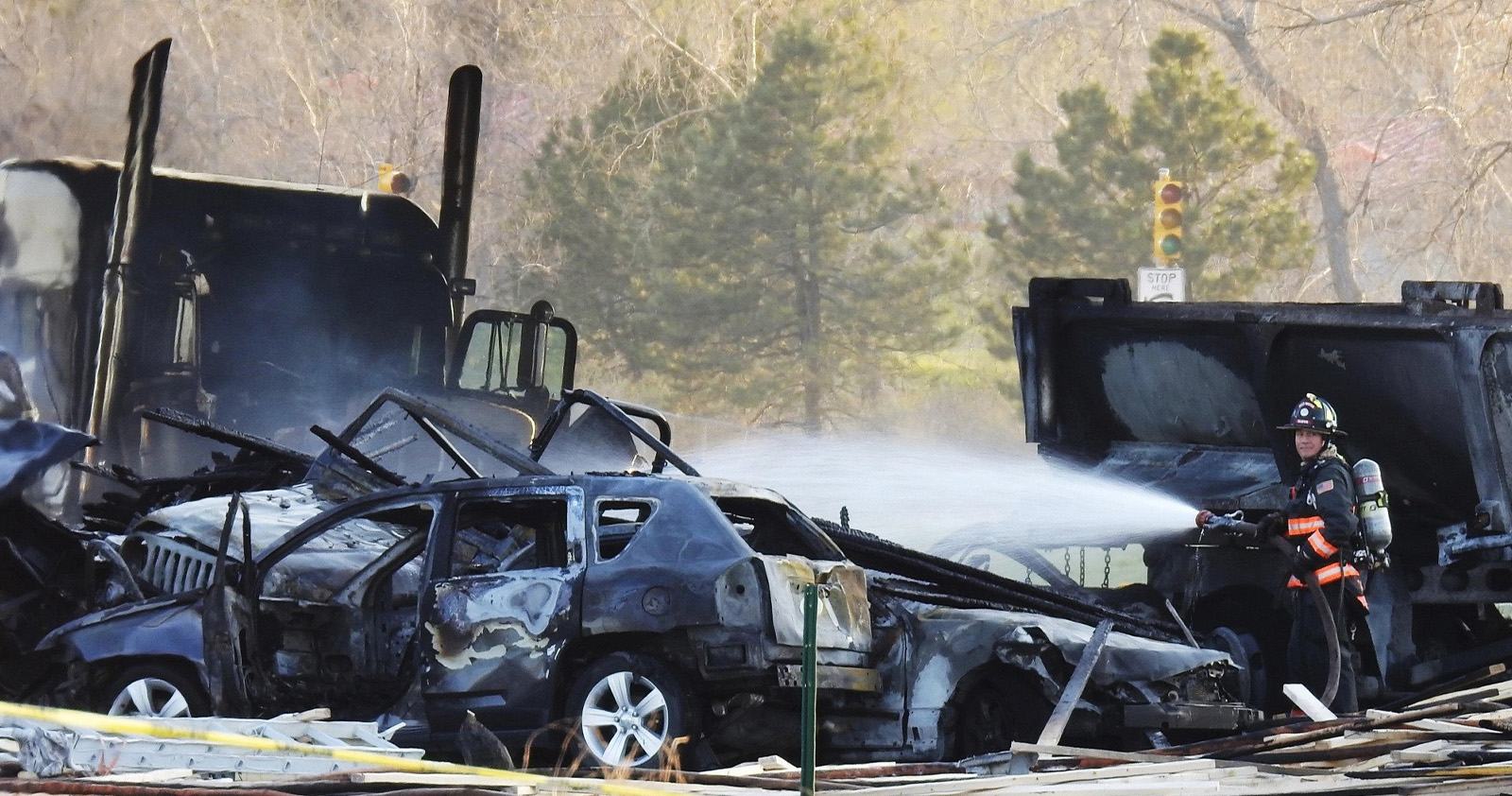Firefighters putting out burning cars in fatal car crash