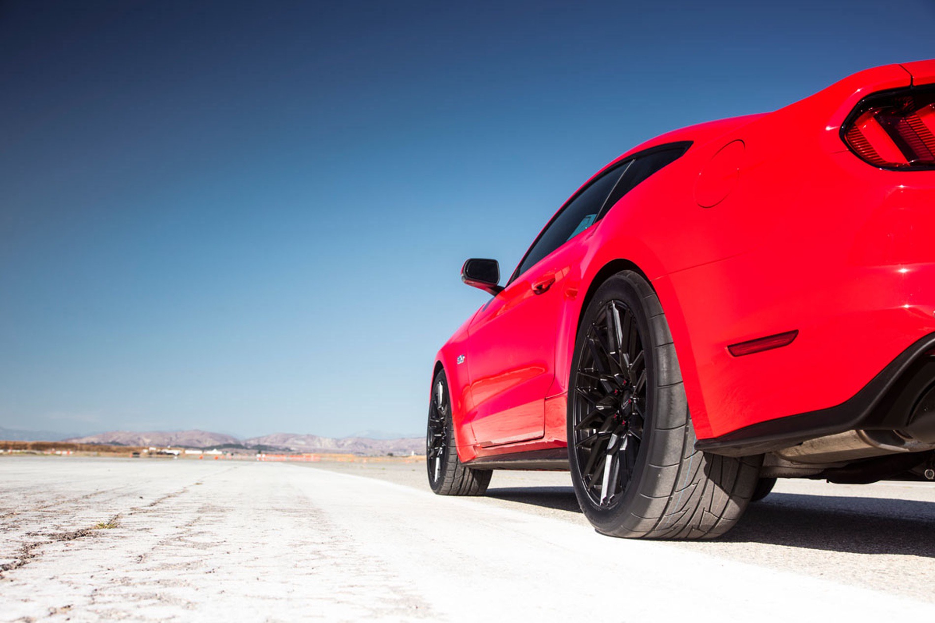 Tires on one side of Ford Mustang in desert